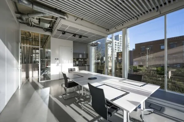 Vergaderruimte met moderne inrichting en grote ramen aan de Fred. Roeskestraat met uitzicht op kantoorpanden.